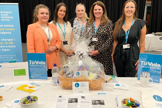 five people behind exhibition desk